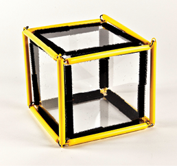 Photo shows a square prism (cube) constructed from Geometro tiles with the corresponding rod model placed over it, in 3-D, viewed from the left.