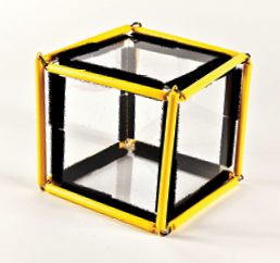 Photo shows a square prism (cube) constructed from Geometro tiles with the corresponding rod model placed over it, in 3-D, viewed from the right.