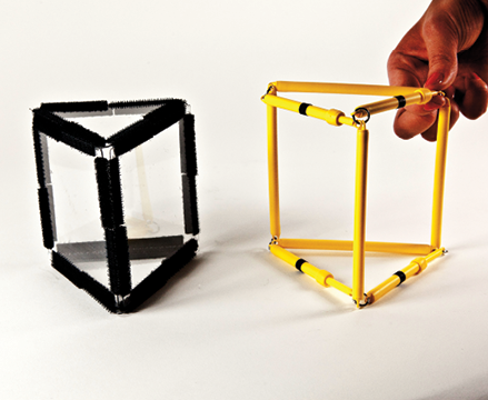 Photo shows a triangular prism constructed from Geometro tiles standing beside the corresponding rod model being held in 3-D, in Position 2.