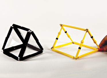 Photo shows a triangular prism constructed from Geometro tiles standing beside the corresponding rod model being held in 3-D, in Position 3, view from left.
