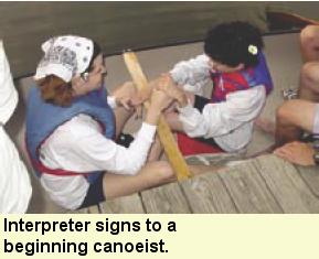 Interperter signs to a beginning canoeist. Photo submitted by Camp Abilities.