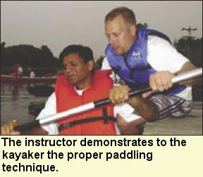 The instructor demonstrates to the kayaker the proper paddling technique. Photo submitted by Camp Abilities.