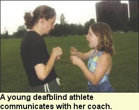 A young deafblind athlete communicates with her coach, Photo submitted by Camp Abilities.