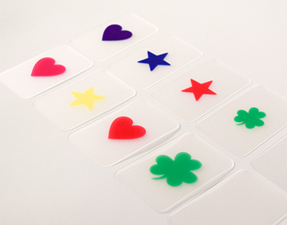 Photograph of ten supplemental cards, two blank and one each of purple heart, pink heart, red heart, large green shamrock, small green shamrock, red star, blue star, and yellow star.