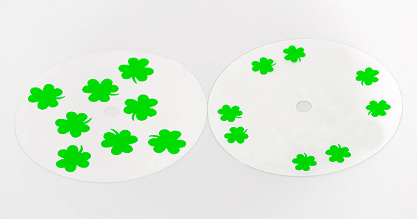 Photograph of a clear overlay with small green shamrocks, and a clear overlay with large green shamrocks.