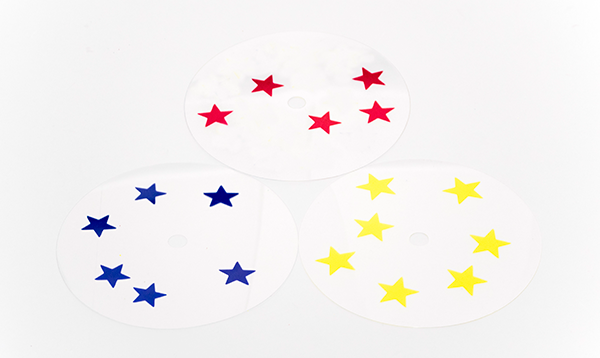 Photograph of a clear overlay with red stars, a clear overlay with blue stars, and a clear overlay with yellow stars.