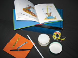 Photo shows an open book, story box, and story box items.