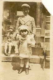 Ten-year-old 'Abie' Nemeth poses with three-year-old sister Marsha in front of his aunt's house in Brighton Beach. Seven-year-old Aaron sits on the steps.