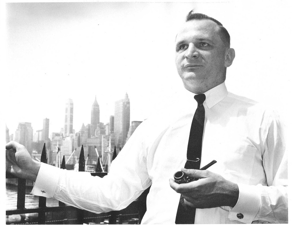 Robert Smithdas poses in front of the skyline of New York City.