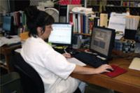 Female transcriber sitting at computer desk.