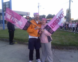 Malcolm and Monica Turner posing with banners that say 'the Future' and 'Embraces' respectively