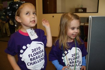 photo of two Braille Challenge students, one wearing a pirate bandana, the other wearing beads.