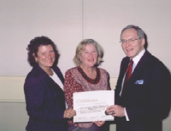 Carol Tobe accepts the award from Terry Davis (left) and Charles Bryan.
