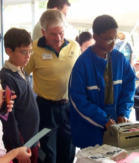 APH's Gary Mudd stands back and lets a young man explore a Perkins Brailler.