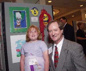 Award winner Ashley Reid poses in front of her artwork with Tuck Tinsley