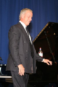 Tom Sullivan standing in front of a piano