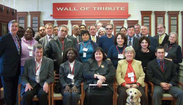 Officers from the World Blind Union gathered in front of the Hall of Fame Wall of Tribute