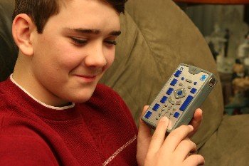 A young man holding a Braille Plus