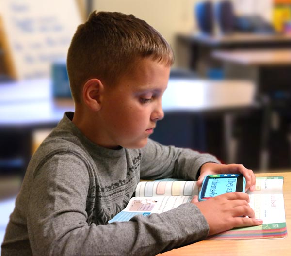 photo of a young student using Video Mag HD to read a textbook in class